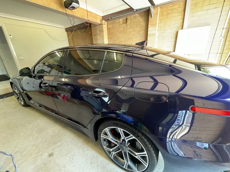 Blue Kia Stinger after a wash and sealant