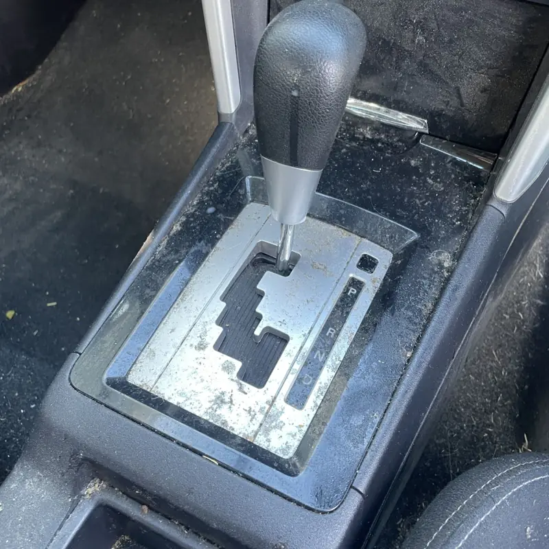 Car detailing in Bradbury: dirty gear shifter surround before cleaning