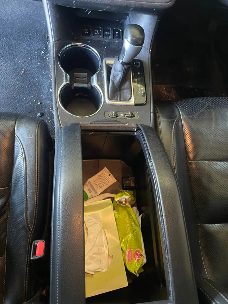 Car detailing in Ashfield: cluttered centre console before cleaning
