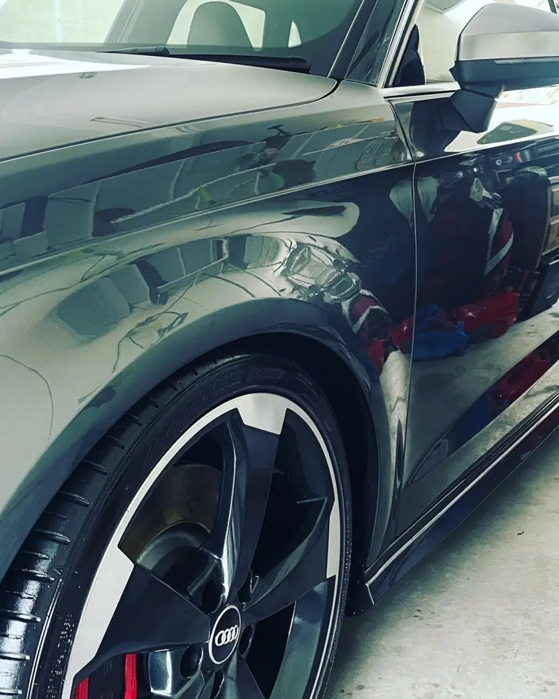 Car detailing in Illawong: black car paint and wheel after polishing